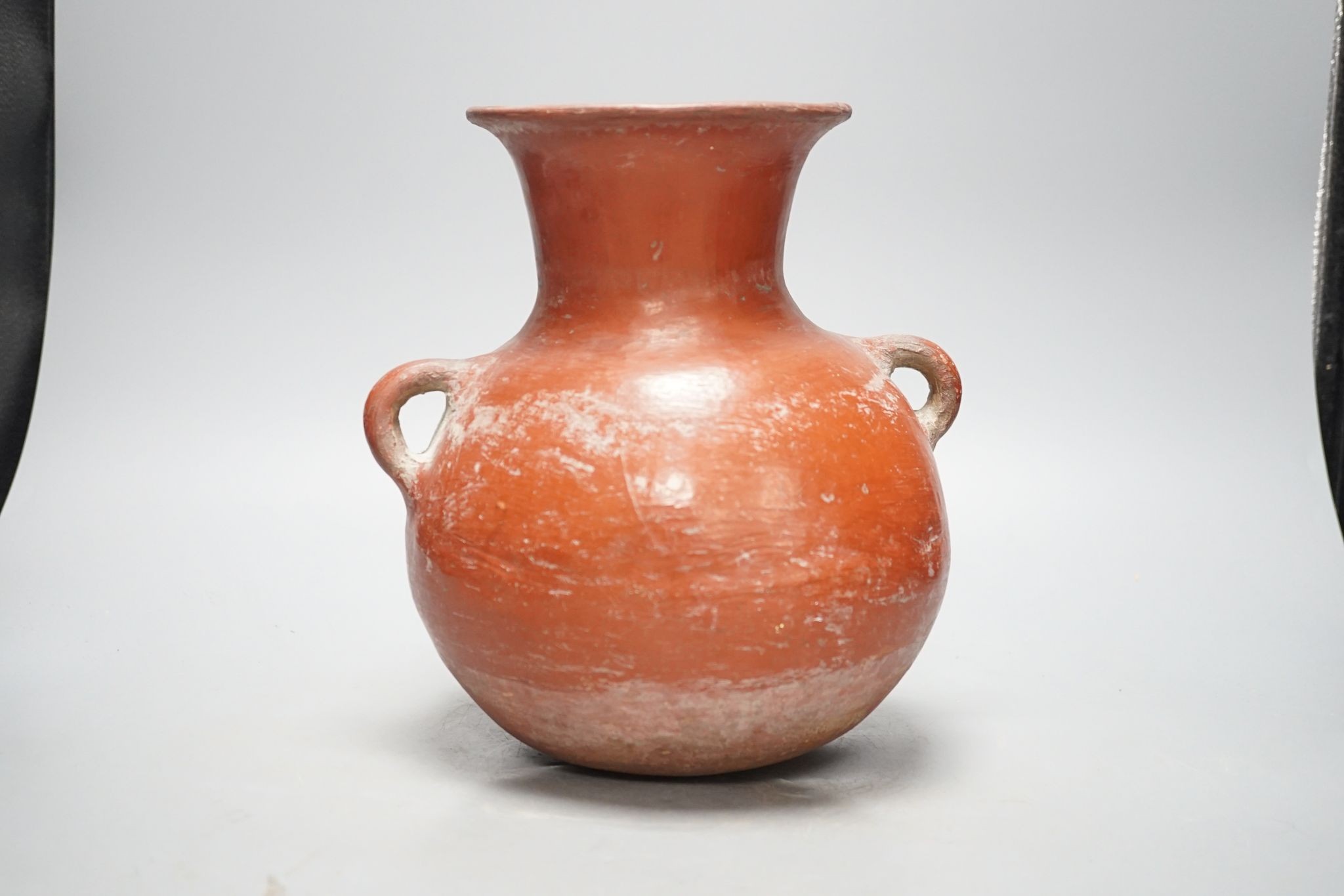 A pre-Columbian black and red pigment decorated two handled pot 25cm